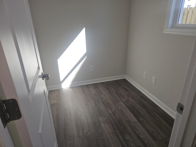 empty room with dark wood-type flooring