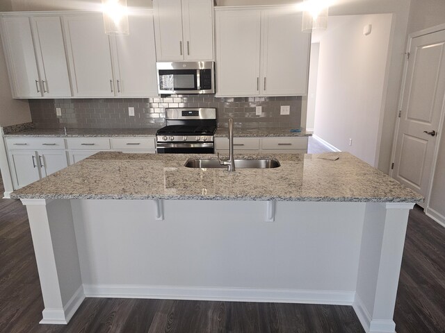 kitchen with a breakfast bar, white cabinetry, sink, and appliances with stainless steel finishes