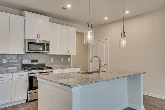 kitchen featuring pendant lighting, sink, an island with sink, white cabinetry, and stainless steel appliances