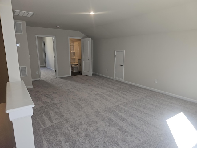 interior space featuring light colored carpet and lofted ceiling