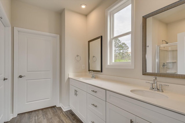 bathroom with vanity, a healthy amount of sunlight, wood-type flooring, and walk in shower