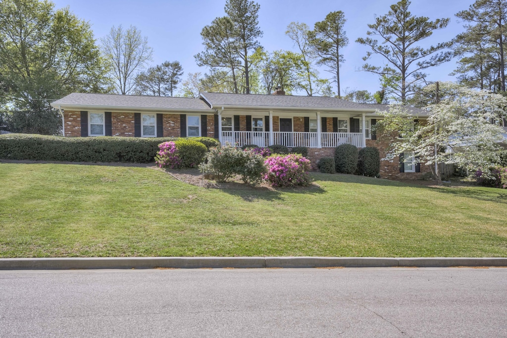 621 Cambridge Rd, Augusta, GA 30909 - single story home featuring a porch, a chimney, a front lawn, and brick siding