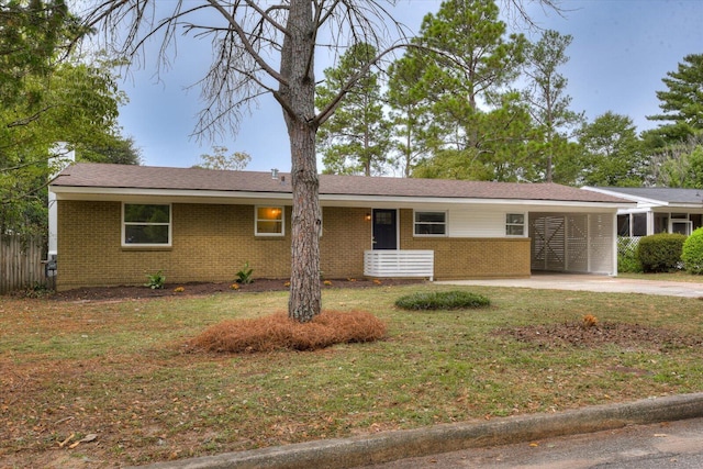 ranch-style home featuring a front lawn and a carport