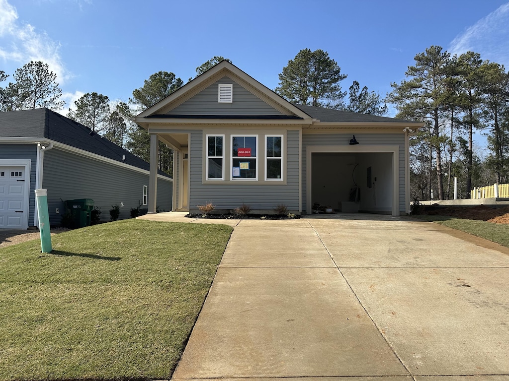 view of front of property featuring a front lawn, driveway, and an attached garage