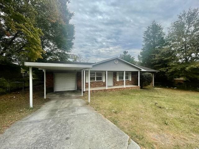 ranch-style house featuring driveway, an attached carport, an attached garage, covered porch, and a front yard