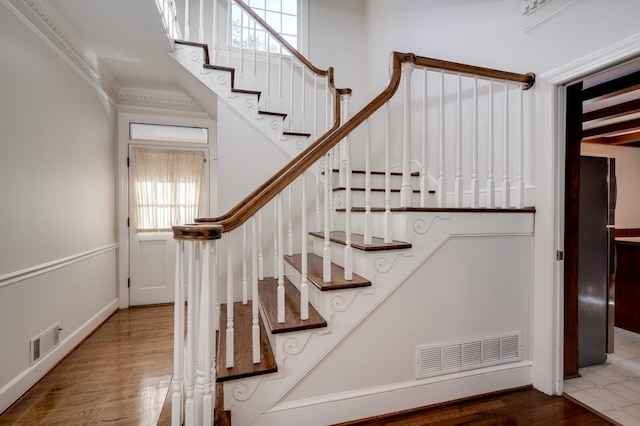 staircase featuring hardwood / wood-style flooring and ornamental molding