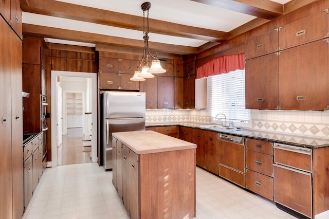 kitchen with a center island, sink, stainless steel appliances, tasteful backsplash, and pendant lighting