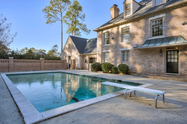 view of swimming pool with a diving board and a patio area