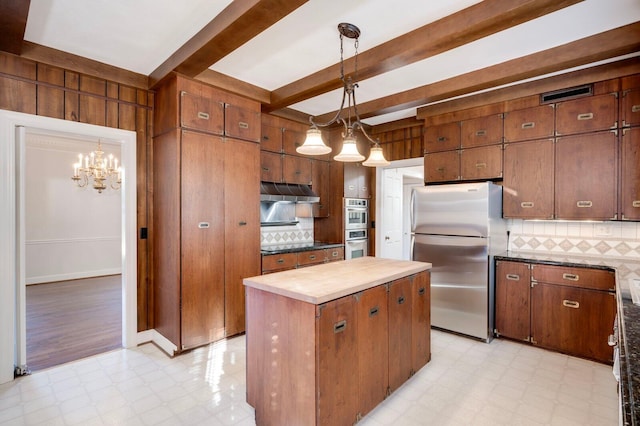 kitchen featuring backsplash, a kitchen island, stainless steel appliances, and decorative light fixtures