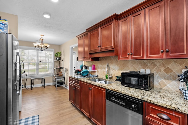 kitchen featuring light wood-type flooring, a sink, tasteful backsplash, stainless steel appliances, and reddish brown cabinets