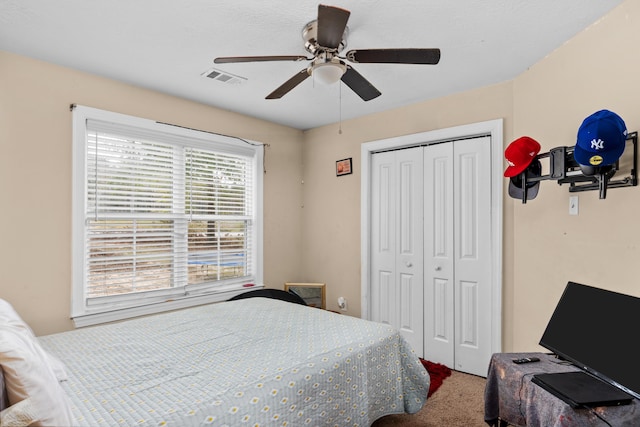 bedroom with visible vents, a closet, ceiling fan, and carpet flooring