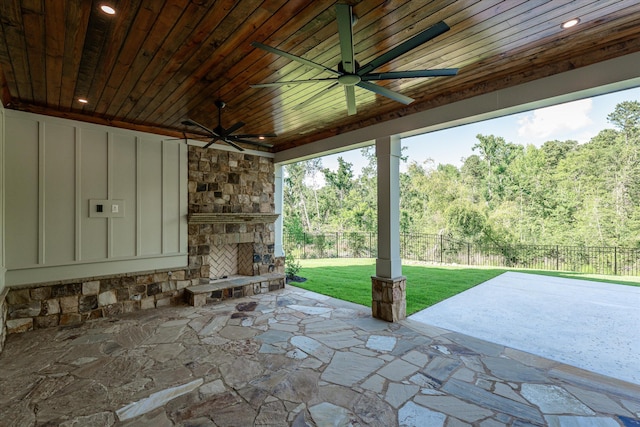 811 Audubon Way, Evans, GA 30809 - fenced backyard featuring an outdoor stone fireplace, ceiling fan, a patio, and a wooded view