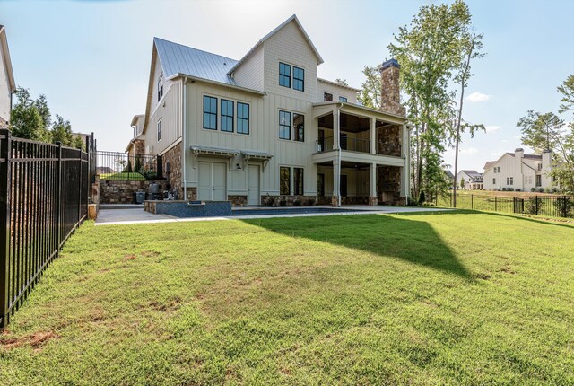 811 Audubon Way, Evans, GA 30809 - back of house with board and batten siding, a metal roof, stone siding, a chimney, and a balcony
