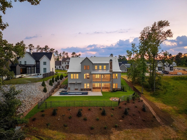 811 Audubon Way, Evans, GA 30809 - back of property at dusk with a standing seam roof, a fenced backyard, an outdoor living space, a metal roof, and a balcony