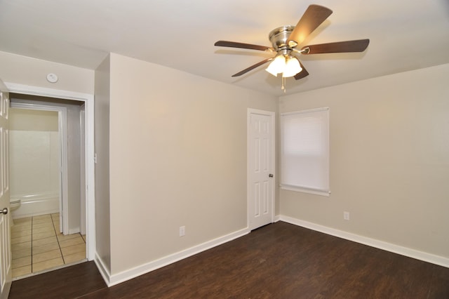 spare room featuring ceiling fan and dark wood-type flooring