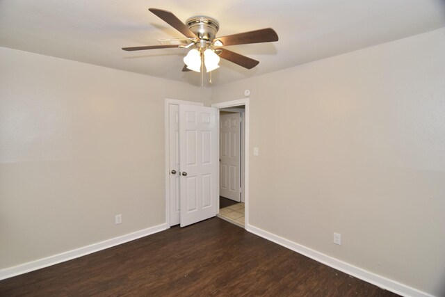 empty room featuring ceiling fan and dark wood-type flooring