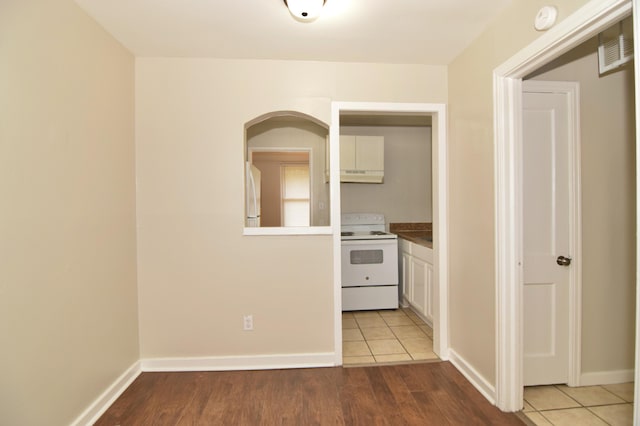 kitchen with white cabinetry, white appliances, and light wood-type flooring