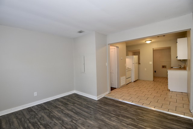 spare room with light wood-type flooring and sink