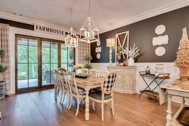 3121 Carillon Way, Evans, GA 30809 - dining area with a chandelier, crown molding, light wood-type flooring, wainscoting, and a decorative wall