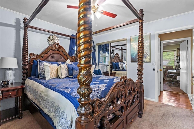 carpeted bedroom with a closet, crown molding, a ceiling fan, and baseboards