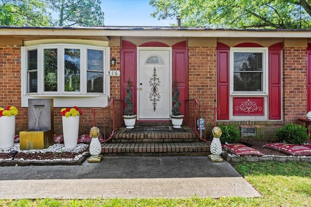 doorway to property featuring brick siding