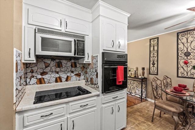 kitchen with black appliances, backsplash, white cabinets, ornamental molding, and baseboards