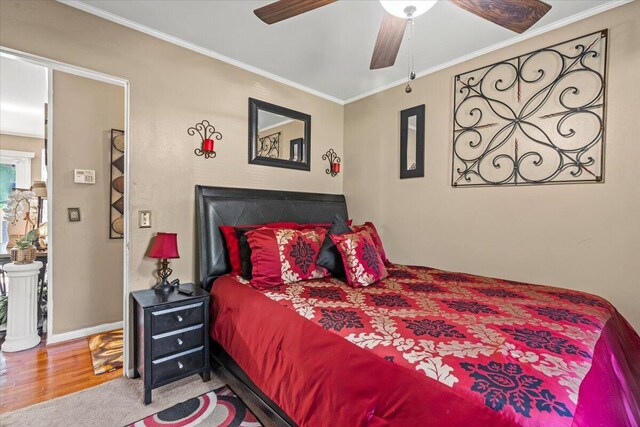 bedroom with ornamental molding, wood finished floors, ceiling fan, and baseboards