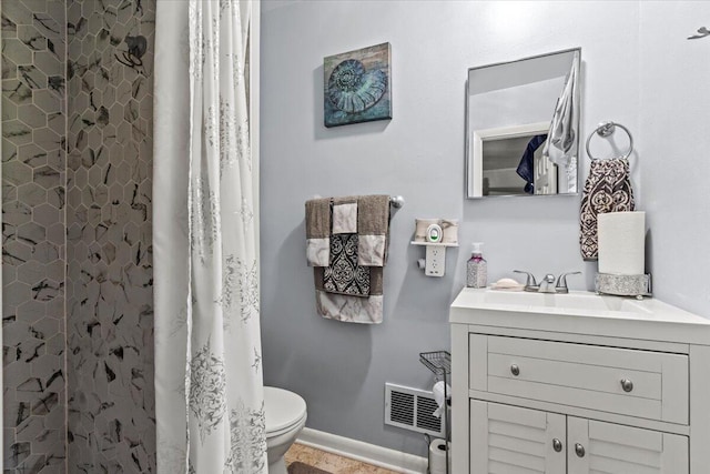 bathroom with vanity, toilet, a shower with curtain, and baseboards