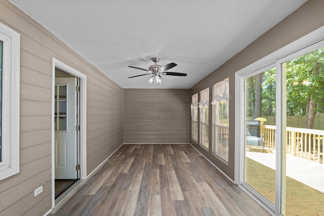 4690 Red Leaf Way, Augusta, GA 30907 - unfurnished sunroom featuring ceiling fan, wood walls, wood finished floors, and a textured ceiling
