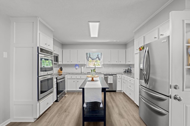4690 Red Leaf Way, Augusta, GA 30907 - kitchen with stainless steel appliances, light wood-type flooring, decorative backsplash, white cabinets, and crown molding