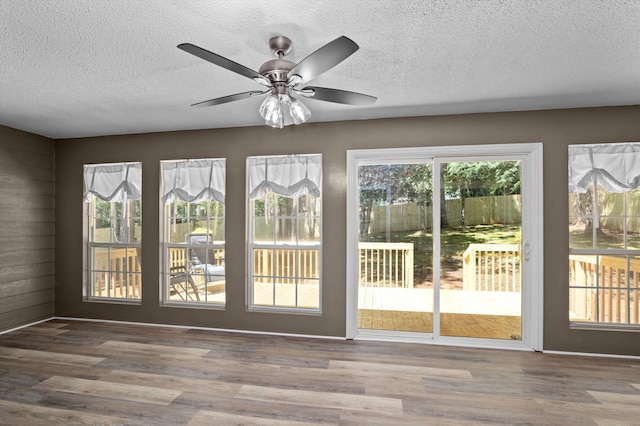 4690 Red Leaf Way, Augusta, GA 30907 - doorway to outside with healthy amount of natural light, a textured ceiling, wooden walls, wood finished floors, and a ceiling fan