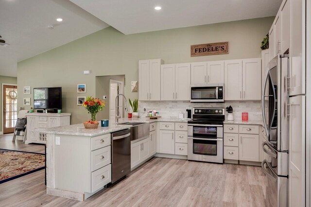 kitchen with decorative backsplash, white cabinetry, sink, and stainless steel appliances