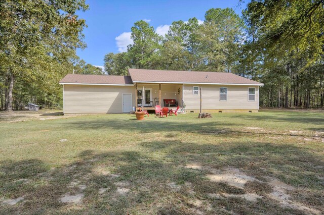 rear view of property featuring a lawn