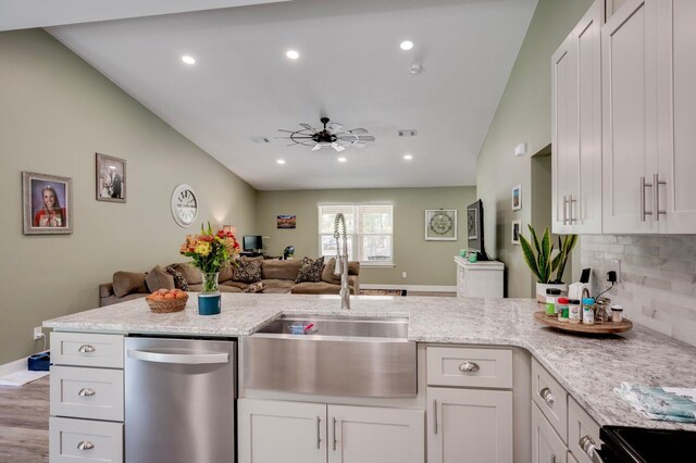 kitchen with dishwasher, backsplash, white cabinets, and sink