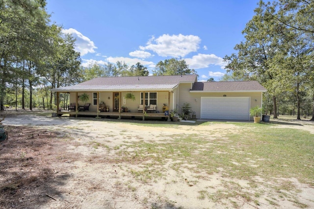 view of front of property featuring covered porch, a garage, and a front yard