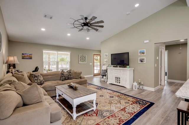 living room with light wood-type flooring, high vaulted ceiling, and ceiling fan