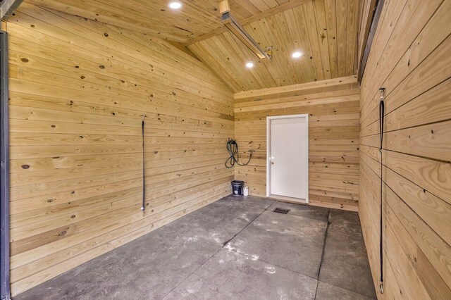 spare room with wooden ceiling, vaulted ceiling, and wooden walls