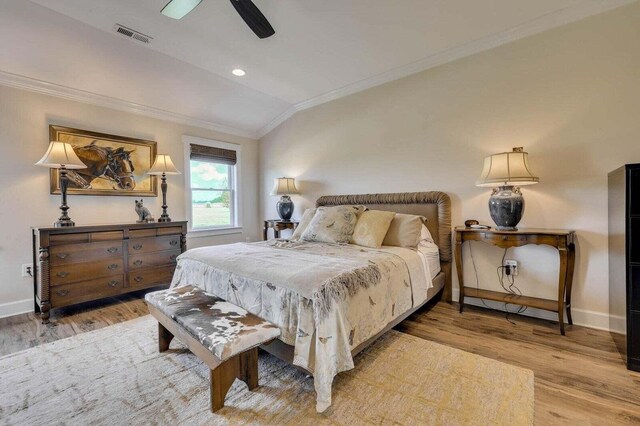 bedroom with ceiling fan, crown molding, light hardwood / wood-style floors, and vaulted ceiling