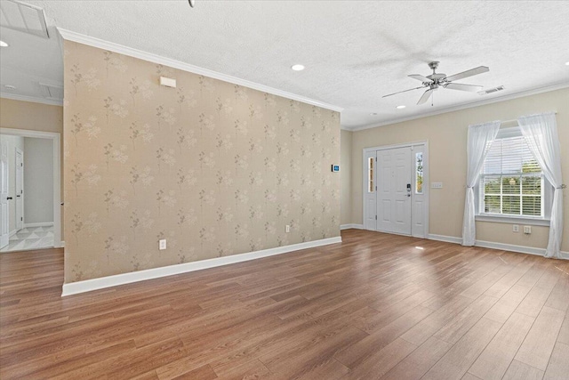 interior space featuring crown molding, ceiling fan, wood-type flooring, and a textured ceiling