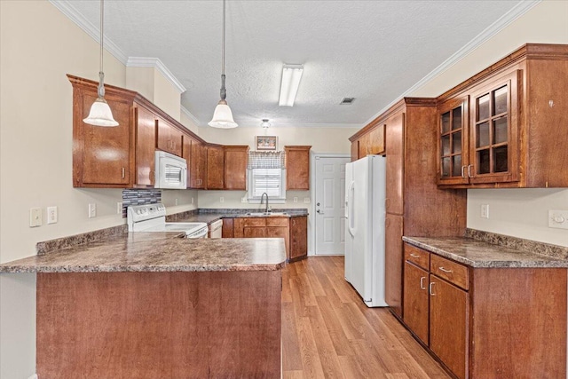 kitchen with kitchen peninsula, a textured ceiling, white appliances, sink, and decorative light fixtures