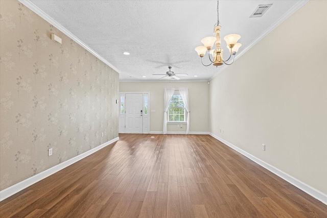 empty room with hardwood / wood-style floors, ceiling fan with notable chandelier, crown molding, and a textured ceiling