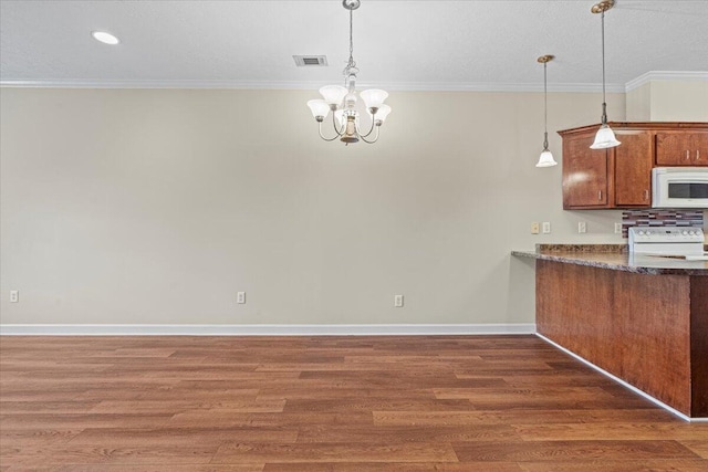 kitchen with pendant lighting, white appliances, an inviting chandelier, dark hardwood / wood-style floors, and ornamental molding