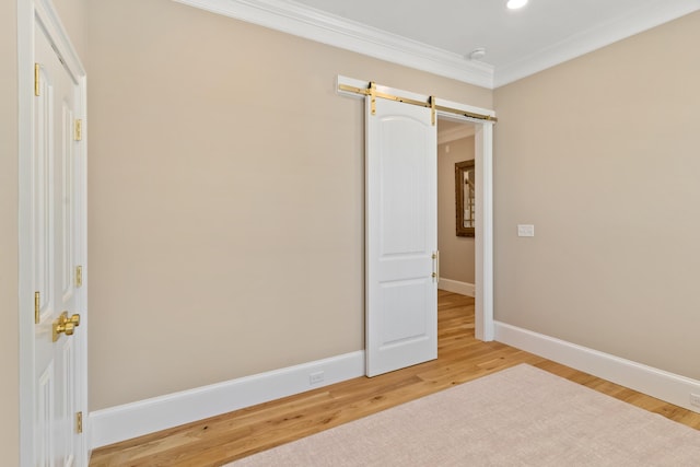 636 Railroad Ave, North Augusta, SC 29841 - unfurnished bedroom with baseboards, light wood-style floors, crown molding, a barn door, and recessed lighting