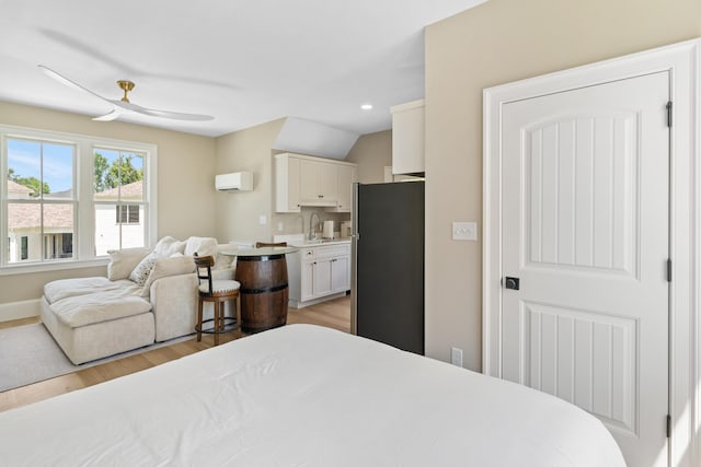636 Railroad Ave, North Augusta, SC 29841 - bedroom featuring freestanding refrigerator, a wall unit AC, a sink, light wood finished floors, and baseboards