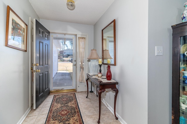 foyer entrance with light tile patterned flooring and baseboards