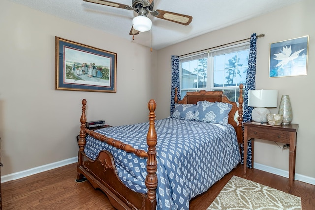 bedroom featuring ceiling fan, baseboards, and wood finished floors