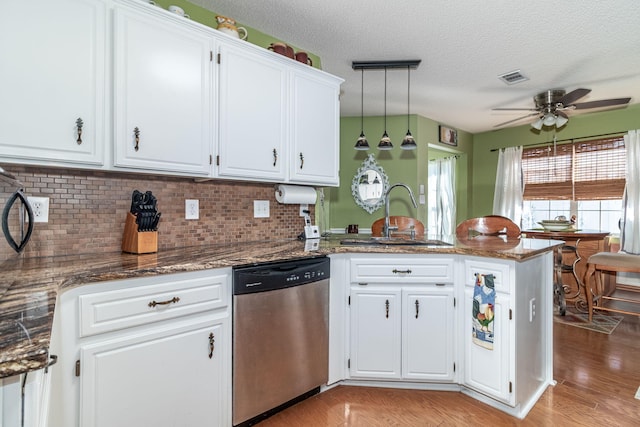 kitchen with stainless steel dishwasher, a sink, visible vents, and white cabinets