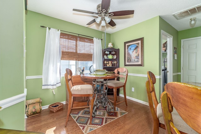 dining room with baseboards, visible vents, and wood finished floors