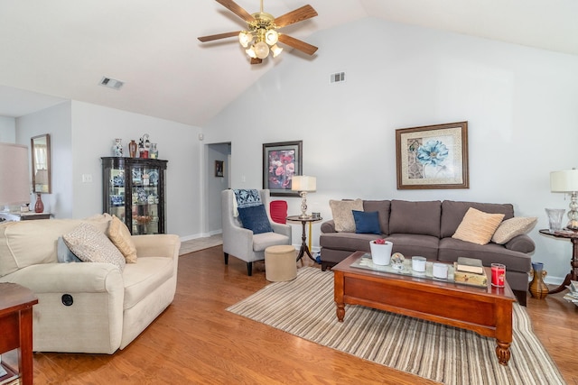 living area featuring ceiling fan, high vaulted ceiling, light wood-style flooring, and visible vents