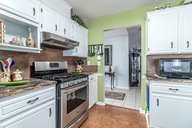 kitchen featuring a textured ceiling, stainless steel range with gas cooktop, white cabinets, and under cabinet range hood